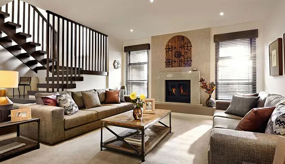 Spacious living room with a fireplace, modern furniture, wooden staircase, and large windows in a home for sale in Post Falls, ID.