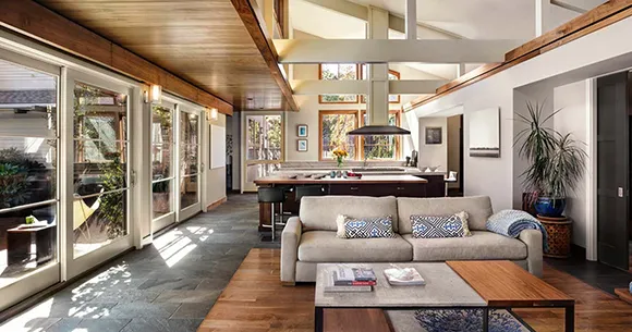 Bright living room interior with large windows, modern furniture, and a staircase, showcasing a spacious home in Post Falls, ID.