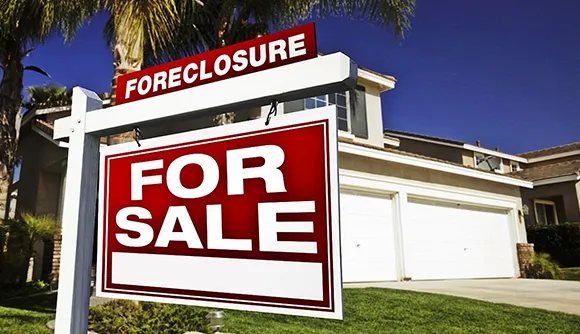 House with a 'For Sale' sign in the yard, representing foreclosure cash buyers in Nampa, ID.