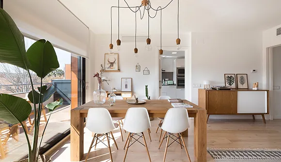 Modern dining room with a wooden table, white chairs, and large windows, promoting quick cash property sales in Spokane, WA.